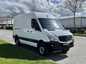 2017 Mercedes-Benz Sprinter van with a white exterior parked on a street showcasing a streamlined design and black accents