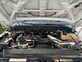 A 2011 Ford F-350 SD engine compartment showing various components including the engine block hoses and fluid reservoirs