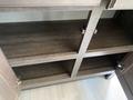 An open cabinet with shelves inside a 2021 Grand Design Recreational ST3478MBS showcasing the wooden structure and hardware
