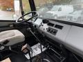 Interior of a 2003 Freightliner FL70 showing the driver's seat dashboard steering wheel gear shift and various controls