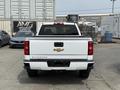 A white 2018 Chevrolet Silverado 1500 pickup truck viewed from the rear showing the tailgate and the Chevy bowtie emblem