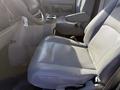 The interior of a 2012 Ford Econoline E-450 featuring a grey leather driver's seat with armrests and a console in between the front seats