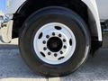 Close-up of a white wheel of a 2017 Ford F-650 Super Duty with multiple black lug nuts and a smooth tire tread