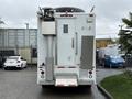 A white 2011 Ford F-650 truck equipped with various external features including a large satellite dish mounted on top and multiple side compartments