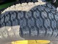 Close-up of a 2016 John Deere 1585 Terrain Cut tire with deep treads designed for traction on various surfaces
