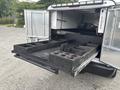 A 2016 RAM 1500 with an open truck bed featuring a custom cargo system with various compartments for tools and equipment