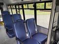 Interior of a 2021 Ford Transit-350 showing two rows of blue fabric seats with seatbelts and a grey floor