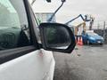A 2021 Mercedes-Benz Metris with a close-up view of its side mirror covered in raindrops