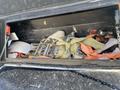 A storage compartment containing various straps and securing equipment including ratchet straps and a metal buckle