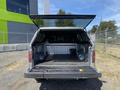 A 2014 Ford F-150 with the tailgate down and a covered truck bed showcasing a clean interior and a rugged liner
