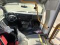 Interior view of a 2020 Chevrolet Express with a steering wheel dashboard and seats visible including a fire extinguisher and control panel