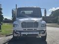 Front view of a white 2022 Freightliner M2 106 truck featuring a chrome grille and high-mounted lights