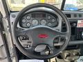 The image shows the steering wheel and dashboard of a 2020 Peterbilt 330 with various controls and gauges displayed