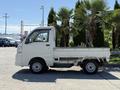 A white 2009 Daihatsu Hijet mini truck showing side view with a flatbed and compact design