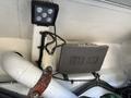 A 2008 Peterbilt 340 dashboard display with gauges and controls mounted on a white surface alongside a square LED light fixture