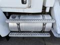 A chrome fuel tank mounted on a metal step plate with a textured surface attached to a large truck