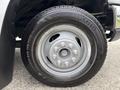 A close-up of a silver wheel on a 2014 Ford E-350 featuring a black Kumho tire with visible tread and lug nuts