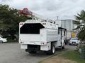 A 2021 Freightliner M2 106 with a raised aerial work platform mounted on the rear and a white body designed for utility service