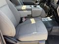 A gray cloth seating area of a 2019 Ford F-550 featuring a center console and armrest between two seats