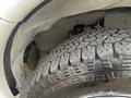 A close-up view of a tire from a 2022 GMC Savana showing a rugged tread pattern and part of the wheel well