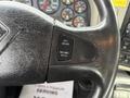 Close-up of a steering wheel control panel featuring buttons labeled SET CRUISE RESUME ACCEL and a textured black grip