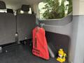 A 2017 Ford Transit with a red fire extinguisher and a yellow jack in the rear cargo area along with dark seatbacks visible