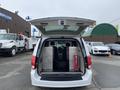 A 2014 RAM Cargo Van with the rear doors open revealing a spacious interior and metal dividers for cargo storage