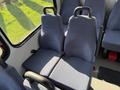 Interior view of a 2017 Chevrolet Express showing two blue fabric seats with seat backs and handles for passenger support
