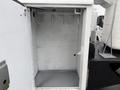 A 2006 Ford F-450 with an open storage compartment featuring white walls and several hooks mounted inside for organizational purposes