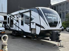 A 2022 Heartland Torque is parked with a sleek black and white exterior featuring a large "TORQUE" logo on the front and angular graphics on the side