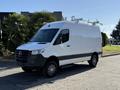 A 2023 Mercedes-Benz Sprinter 2500 van in white with a black front and roof racks on top