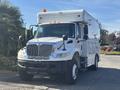 A 2008 International 4400 truck with a white exterior and an enclosed cargo area parked in a driveway