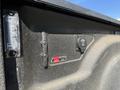 Close-up of the interior side of a truck bed showing a light fixture a sticker and a tie down hook