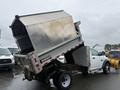 A 2011 Dodge Ram 5500 truck with a raised dump bed showcasing its cargo area and hydraulic lift mechanism