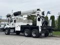 A white 2013 Freightliner 114SD truck with a hydraulic boom and bucket attachment on the back designed for utility work