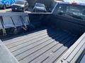 A 2018 Ford F-150 truck bed with a lined surface and no items inside showing metal tie-downs along the sides