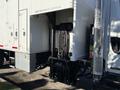 A 2011 Freightliner M2 106 truck with a liftgate attachment at the rear for loading and unloading cargo