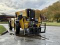 A yellow 2014 Caterpillar TL1055C telehandler with a black fork attachment positioned at the front and large wheels designed for lifting and moving heavy loads