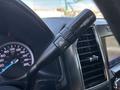 Close-up of the gear shift lever on a 2022 Ford F-350 SD featuring buttons for drive mode adjustment and a digital speedometer in the background