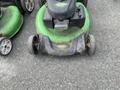 Three Honda Lawnboy mowers with green bodies and two Stihl line trimmers with black and orange designs are displayed in the foreground