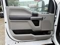 A close-up of the driver side door panel of a 2020 Ford F-550 featuring a gray and black interior design with window and lock controls