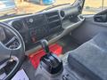 Interior view of a 2018 Hino 195 showing the driver's seat gear shift panel and dashboard controls with storage compartments and a radio display