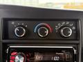 A close-up view of the dashboard controls of a 2013 Chevrolet Express showing climate control knobs and a Pioneer stereo system display