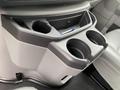 Interior view of a 2010 Ford Econoline showing the center console with cup holders and a storage compartment