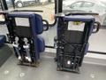 Two folded seats from a 2020 Chevrolet Express with blue upholstery and metal frames positioned against a wall
