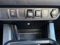 The interior console of a 2021 Toyota Tacoma featuring various control buttons and a USB port