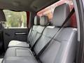 Interior view of a 2013 Ford F-550 showing the rear seating area with three leather seats and seat belts