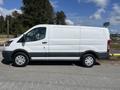 A 2017 Ford Transit van in white color with sliding side door and large cargo area visible from the side angle