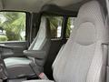Two gray upholstered front seats of a 2004 Chevrolet Express van with a clean interior design and armrests