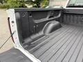 The image shows the bed of a 2016 GMC Sierra 1500 with a black spray-on bed liner and a smooth textured surface with no visible cargo or accessories inside